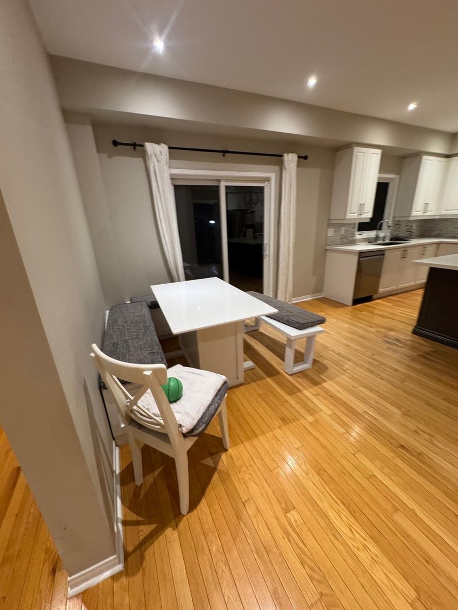 Bright, freshly cleaned dining area with hardwood floors and white table
